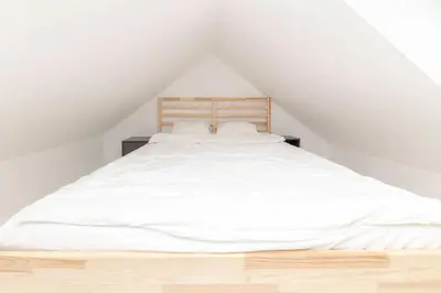 a white bed with white sheets and pillows at Studio Nensi in Ljubljana