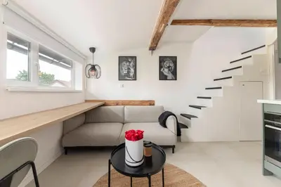 a living room with a couch and stairs at Studio Nensi in Ljubljana