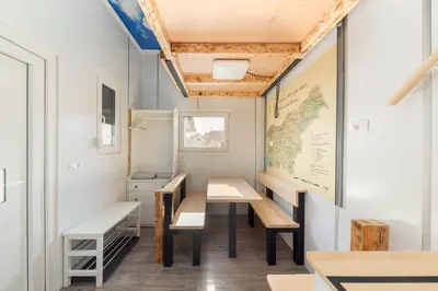 a classroom with benches and a map on the wall at Tiny House Ljubljana in Ljubljana
