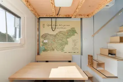 a room with a table and a map on the wall at Tiny House Ljubljana in Ljubljana