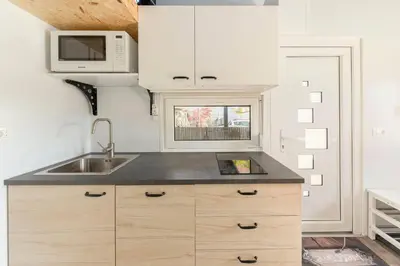 a kitchen with a sink and a microwave at Tiny House Ljubljana in Ljubljana