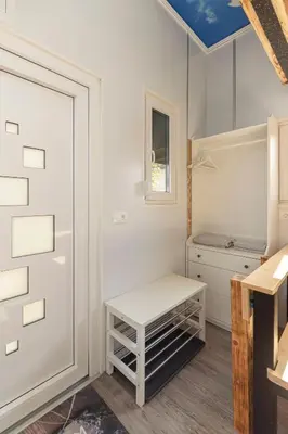 a white closet with a bench and a window at Tiny House Ljubljana in Ljubljana