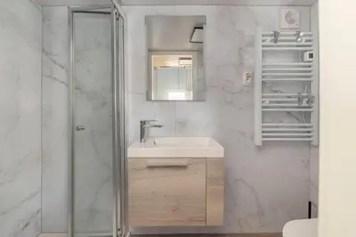 a bathroom with a sink and a glass shower at Tiny House Ljubljana in Ljubljana