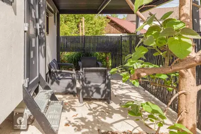a patio with chairs and a fence and a tree at Tiny House Ljubljana in Ljubljana