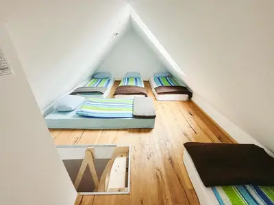 a room with three beds in a attic at Koča ob izviru Soče in Trenta