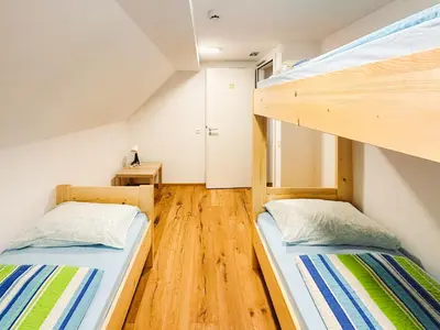 two bunk beds in a room with wooden floors at Koča ob izviru Soče in Trenta