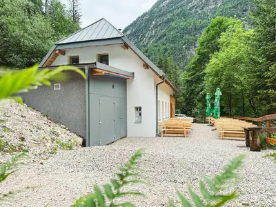 a building with a bunch of wooden benches in front at Koča ob izviru Soče in Trenta