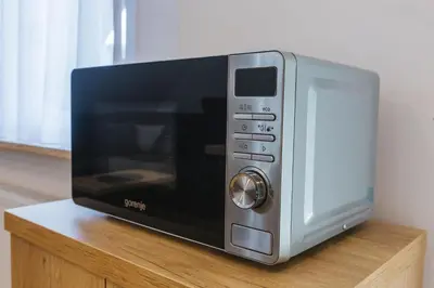 a microwave oven sitting on top of a wooden table at Apartma Bistr'ca in Bohinj