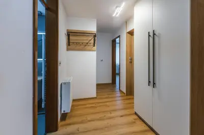 a hallway with white walls and wooden floors at Apartma Bistr'ca in Bohinj