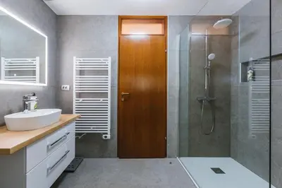 a bathroom with a sink and a shower with a glass door at Apartma Bistr'ca in Bohinj