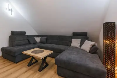 a living room with a couch and a table at Apartma Bistr'ca in Bohinj
