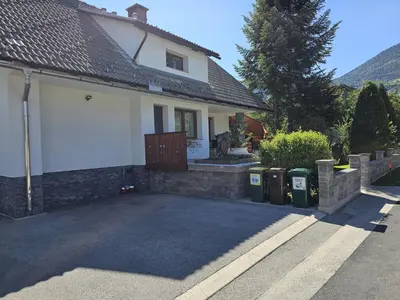 a house with two trash cans in front of it at Apartma Bistr'ca in Bohinj