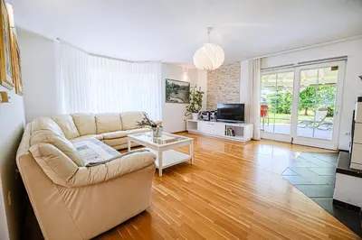 a living room with a couch and a television at Holiday Home Slavc with 4 Bedrooms in Brežice