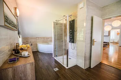 a bathroom with a shower and a bath tub at Holiday Home Slavc with 4 Bedrooms in Brežice