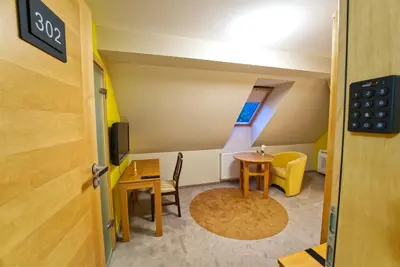a room with a table and a chair and a tv at Vila Sofia in Tržič