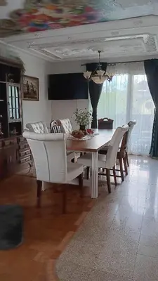 a dining table and chairs in a living room at Hiša Piber in Bled