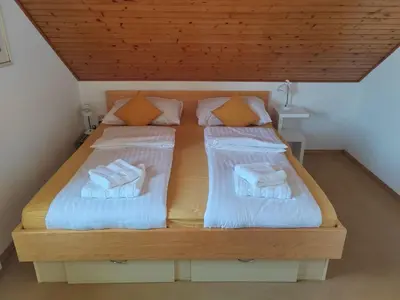 a bedroom with two beds with white sheets and pillows at Hiša Piber in Bled
