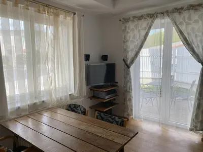 a living room with a wooden table and a television at Lavender in Postojna