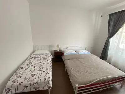 two beds in a small room with a window at Lavender in Postojna