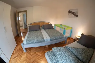 two beds in a room with wooden floors at Apartments Field Flower in Radovljica