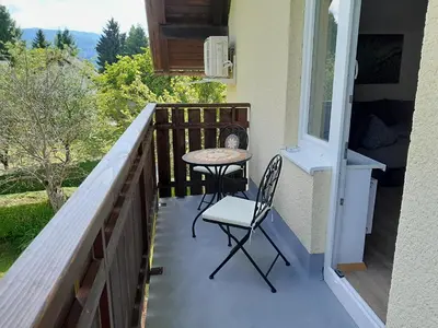 a patio with a table and chairs on a balcony at Apartments Field Flower in Radovljica