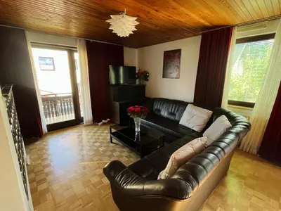 a living room with a leather couch and a television at Grand Cesar Bled in Bled