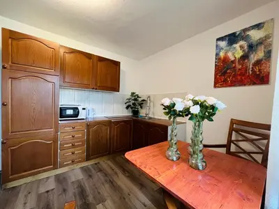 a kitchen with a table with vases of flowers on it at Grand Cesar Bled in Bled
