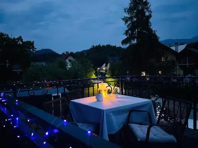 a white table with candles and lights on a balcony at Grand Cesar Bled in Bled