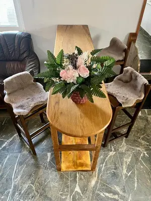 a wooden table with a bouquet of flowers on it at Grand Cesar Bled in Bled