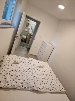 a bed in a small room with a bedspread on it at Mediteran Apartments in Koper