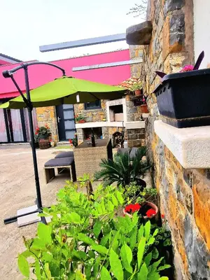 a patio with a green umbrella and some plants at Mediteran Apartments in Koper
