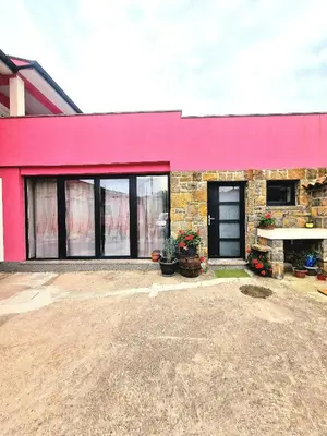 a pink building with plants in front of it at Mediteran Apartments in Koper