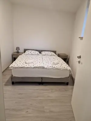 a bedroom with a bed in a white room at Mediteran Apartments in Koper