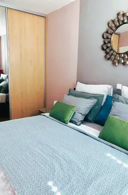 a bed with green and blue pillows in a room at Stylish Boutique Apartment in Ljubljana