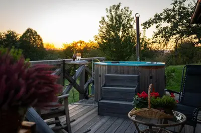 a deck with a hot tub and a table with flowers at Johanca in Obrov