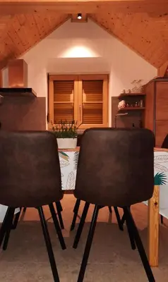 two black chairs in a room with a table at Hiša Ella in Žaga