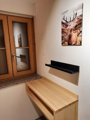 a room with a cabinet and a picture of a deer on the wall at Hiša Ella in Žaga