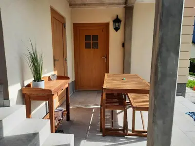 a wooden table and chairs in front of a door at Hiša Ella in Žaga