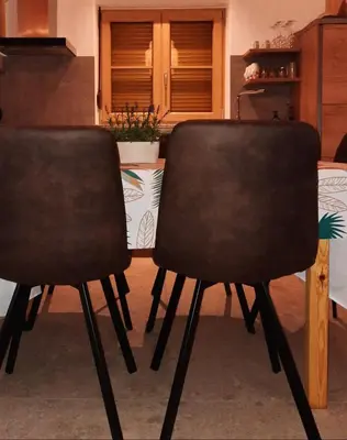 two black chairs sitting next to a table at Hiša Ella in Žaga
