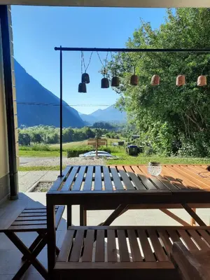 a wooden bench sitting on a porch with a view at Hiša Ella in Žaga