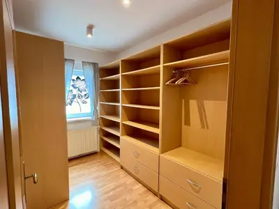 a walk in closet with wooden shelves and a window at Apartment Šentjur center in Šentjur