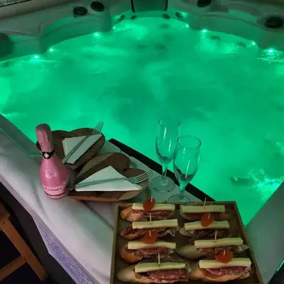 a table with sandwiches and wine glasses next to a swimming pool at Apartma in wellness Mesečina in Libeliče