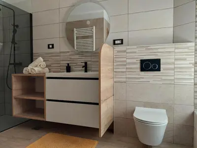 a bathroom with a sink and a toilet and a mirror at Studio apartment Under the castle in Škofja Loka