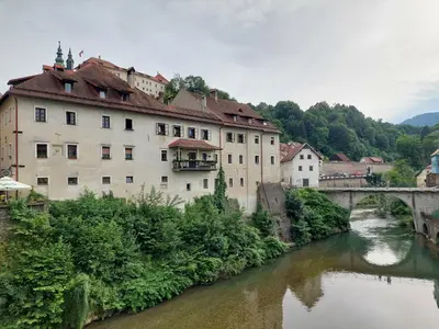 a bridge over a river next to a building at Studio apartment Under the castle in Škofja Loka