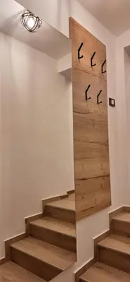 a staircase with wooden stairs and a mirror on the wall at Studio apartment Under the castle in Škofja Loka