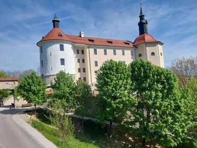a large white castle with a red roof at Studio apartment Under the castle in Škofja Loka