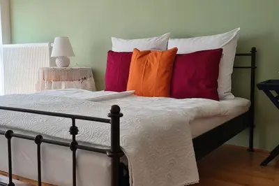 a bed with colorful pillows and a laptop on it at Heaven Can Wait Country Retreat in Poljane nad Škofjo Loko