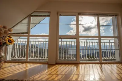 an empty room with large windows with a view of the ocean at Heaven Can Wait Country Retreat in Poljane nad Škofjo Loko
