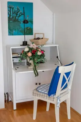 a white desk with a vase of flowers and a chair at Heaven Can Wait Country Retreat in Poljane nad Škofjo Loko