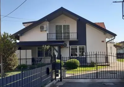 a house with a black fence in front of it at Apartma Špela in Slivnica pri Mariboru